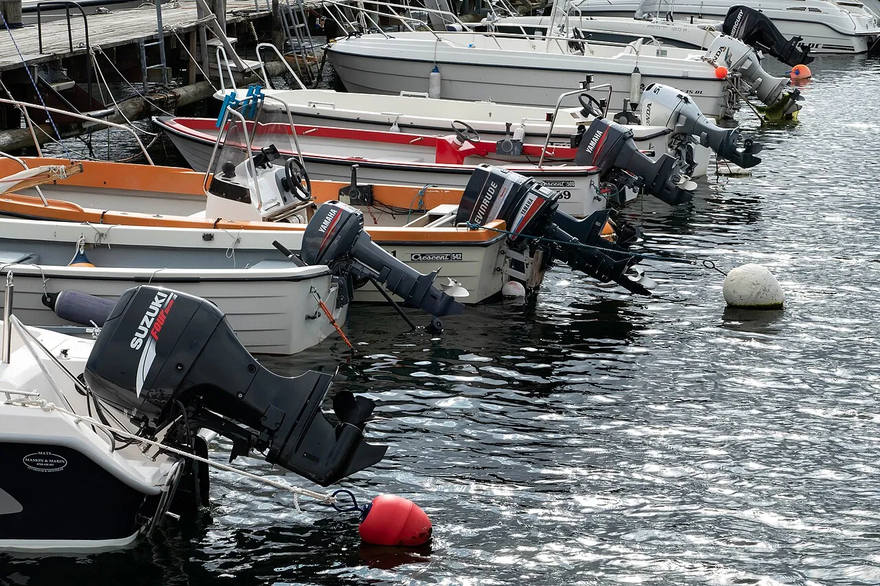 Mange småbåter med påhengsmotorer fortøyd tett ved en brygge